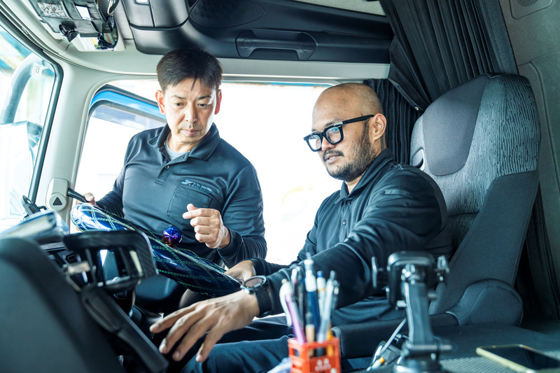 海上コンテナ事業でトレーラーを運転する外国人スタッフと指導員の日本人幹部社員
